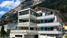 3 story apartment building, white exterior, blue shutters, balconies, garage, mountain view