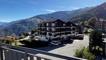 large chalet style building with mountains in the background