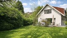 modern single family house, white walls, red roof, large garden, patio, raised ground floor