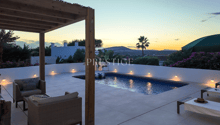 Outdoor area with swimming pool, lounge chairs, umbrella, and a view of the sunset