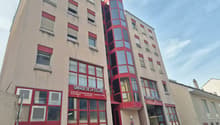 Multi-story building, red trim, large windows, underground garage