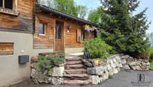Villa / a wooden house with a stone wall and plants on the wall