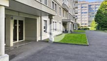 Entrée de l'immeuble avec parking visiteurs dans rue calme