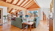/ a large open room with wooden ceilings and furniture