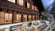 wooden chalet, wooden deck, cozy furniture, glass doors, view of mountains