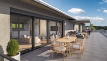 Terrace with table and chairs, potted plant, sliding glass doors, furniture inside visible, couple standing outside