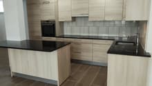 modern kitchen with wooden cabinets, black countertops, tiled floor, built-in oven, dishwasher, sink