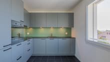 Modern kitchen, gray cabinets, black countertops, stainless steel faucet, large window