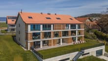 modern house, red roof, large windows, multiple balconies, raised ground floor, garden, stairs