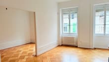 Empty room, white walls, wooden parquet floor, large windows, radiator