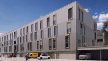 Large office building, grey and yellow exterior, multiple windows, underground parking