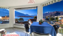 dining room with balcony, table, chairs, view of mountains and lake