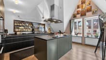 modern kitchen with island, wine rack, large windows, wooden floor