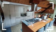 White kitchen cabinets, stainless steel appliances, wooden countertop, gas stove with chimney hood