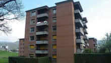 An apartment building with a modern architecture design, many balconies, and yellow windows