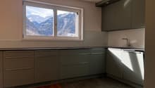 modern kitchen, gray cabinets, black countertops, window with mountain view, sink with faucet