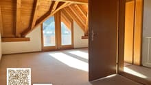 empty attic room with wooden ceiling, carpeted floor, large windows, open door