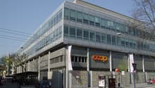 modern office building with large windows, COOP banner on the front, colorful murals on the walls