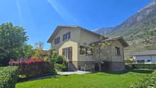 2 story house, yellow exterior, brown shutters, mountain view, garden, bench
