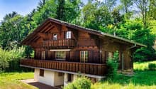Traditional wooden house, 2 story, balcony, surrounded by greenery