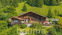 wooden house, hillside, large balcony, surrounded by green hills