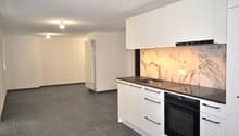 empty kitchen with white cabinets, tiled floor, sink, oven, large fridge