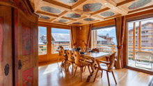 Dining table, wooden chairs, large windows, balcony with table and chair, wooden flooring, decorative ceiling
