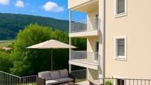 Apartment building with beige walls, multiple balconies, patio with outdoor furniture, a sofa, a table, an umbrella and a plant in a pot.