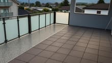 large balcony, black railing, white panels, tiles, mountain view