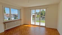 empty room, wooden parquet floor, large windows, sliding glass doors, balcony, white walls, white radiator