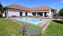 Modern house with swimming pool, wooden deck, and garden