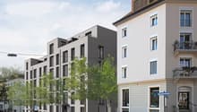 3-story apartment building with 12 units, modern design, white exterior, balcony, trees and shrubs landscaping