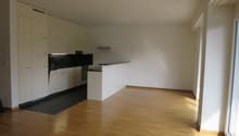 modern kitchen with white cabinets, wooden floor, black countertop, modern appliances