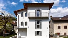 modern white house, brown roof, balcony, windows with shutters, garden, lawn
