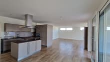 modern kitchen with wooden floor, white walls, built-in appliances, large windows