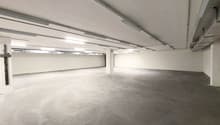 empty room, white walls, gray floor, fluorescent lights on ceiling