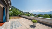 tiled floor, potted plant, wall, railing, mountain view