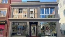 3-story building with 2nd floor balcony, 2 entrance, 3 windows, plants, street view