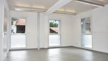 Empty room with sliding doors, windows, tiled floor, and overhead lighting.