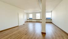 empty room, wooden floor, white walls, three windows, central pillar, white door