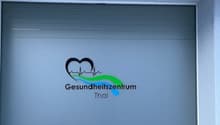 A gray entrance with a logo and the words 'Gesundheitszentrum Thal' on it.