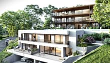Modern two-story house with balconies, raised ground floor, and garage