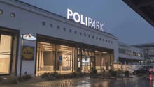 Polipark building with a large sign, multiple circular windows, and a parking area in front