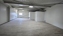 large open room, wooden floors, white walls, metal ceiling, small window