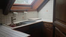 kitchen with sink, faucet, chopping board, wooden cabinets, tiled floor, attic window
