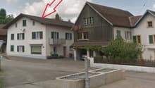 Two story house, white paint, wooden house at back, garage