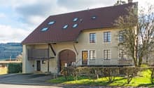 2 story house, brown roof, beige walls, wooden door, windows, balcony, driveway