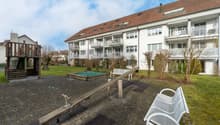 Large garden with play area, two benches, grassy area, and a covered pit for jumping