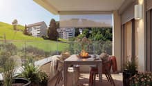 Balcony with table and chairs, glass railing, plants, view of the hills