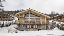 log chalet with wooden balconies, stone foundation, wooden interior, nestled in snowy mountainous landscape